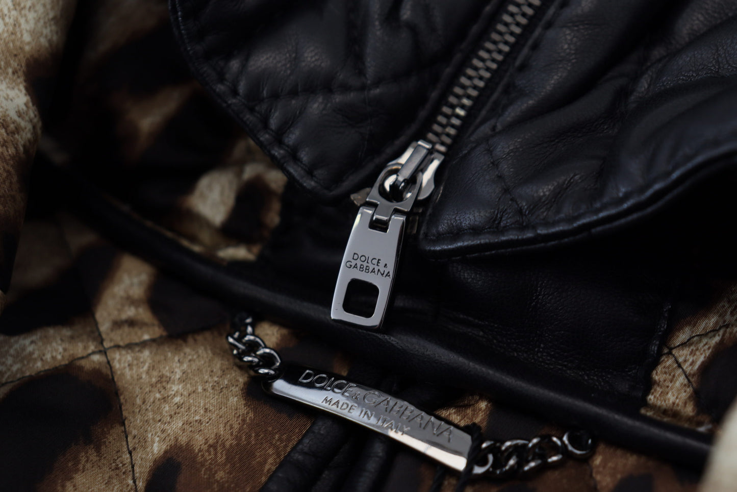 Schwarze gesteppte Lederjacke mit Kapuze und Knopf