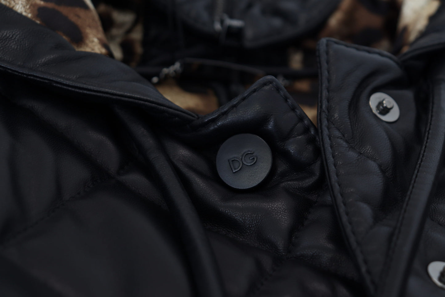 Schwarze gesteppte Lederjacke mit Kapuze und Knopf
